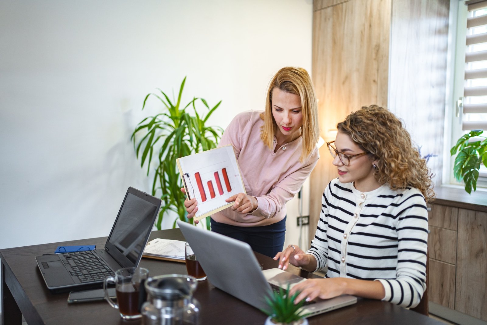 Two female colleagues working together on business report